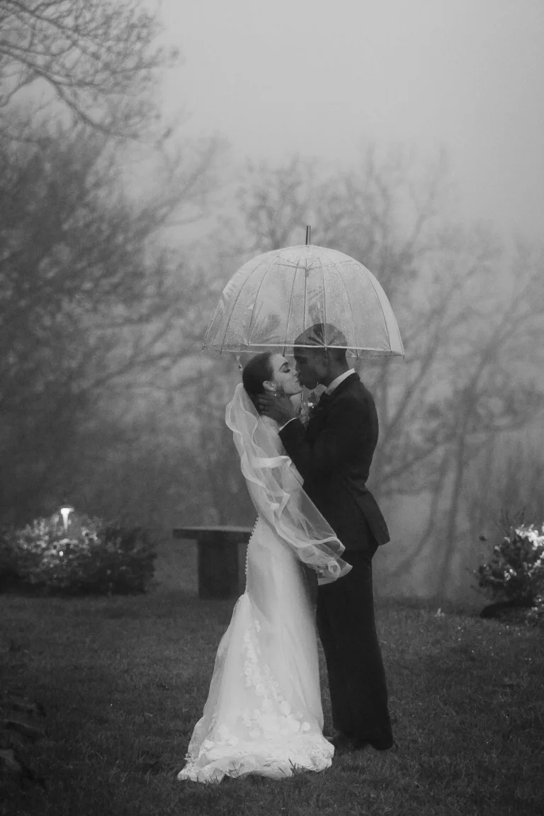 Bride & groom kissing in the rain