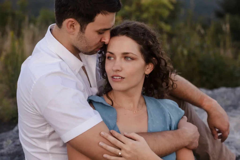 Man hugging fiancee in the Asheville mountains