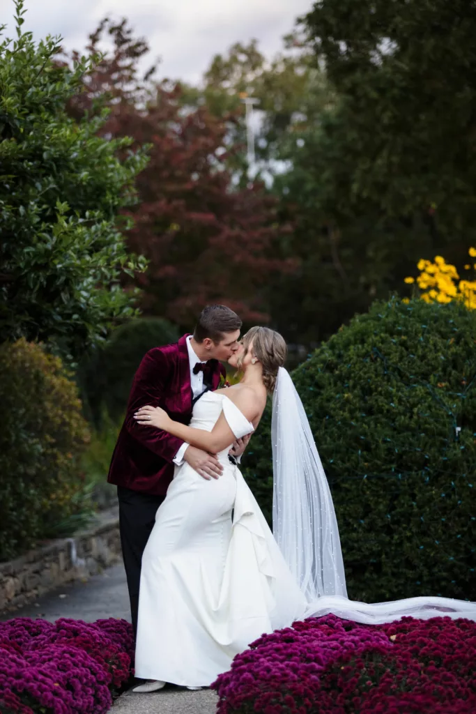 Arboretum wedding in Asheville, groom kissing bride, they are surrounded by flowers