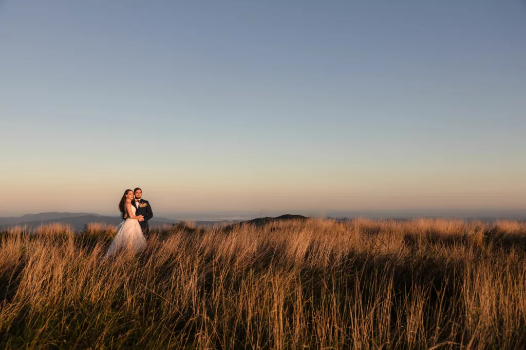 Asheville elopement - bride and groom looking into the sunset with mountains behind them