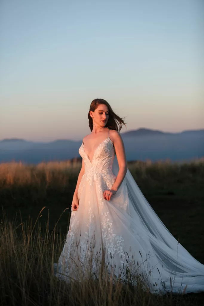 Bride att sunrise in the blue ridge mountains. She is in her white wedding dress.