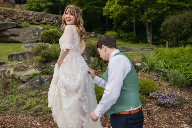 Groom taking out leaves from bride’s dress