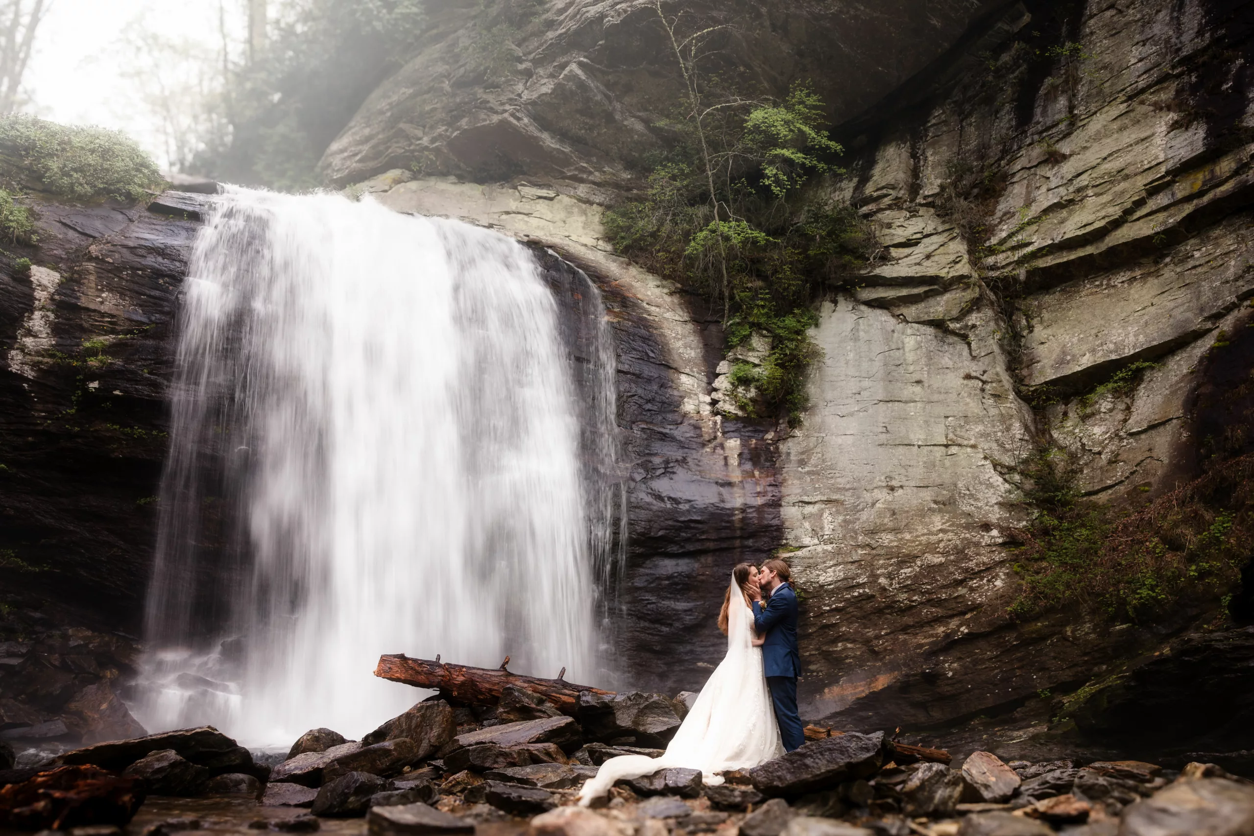 Asheville-elopement-at-a-waterfall-couple-kissing-looking-glass